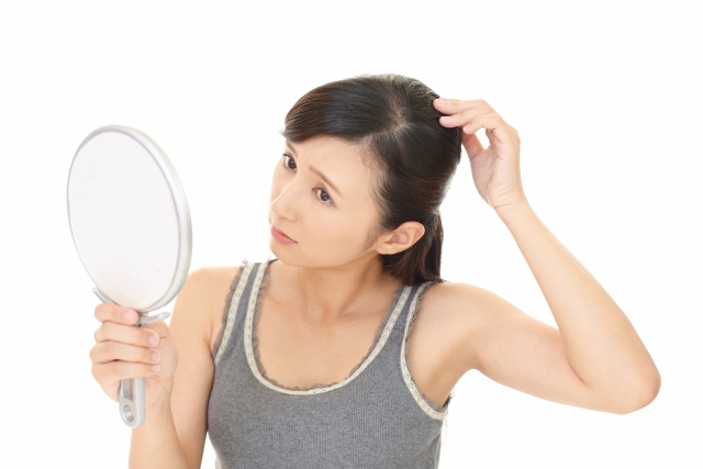 薄毛を鏡で確認する女性 | 脳活整体ルーム APLO(アプロ)