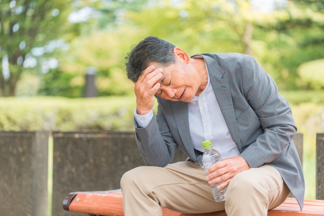 公園で頭を抱える男性 | 脳活整体ルーム APLO（アプロ）