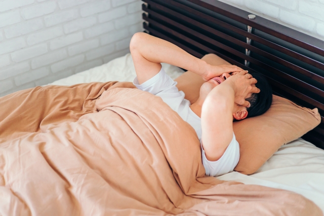 不眠症に悩み頭を抱える男性 | 脳活整体ルーム APLO(アプロ)